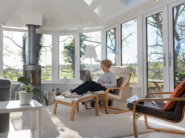 A lady sitting in a solid roof conservatory